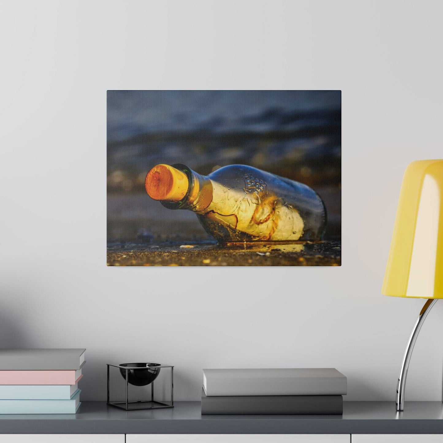 an empty bottle sitting on a table next to a lamp