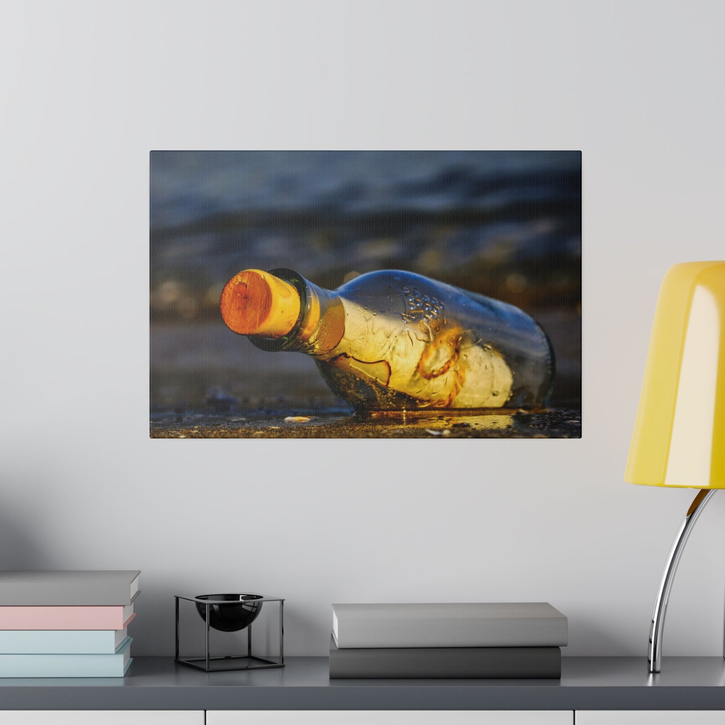 an empty bottle sitting on a table next to a lamp