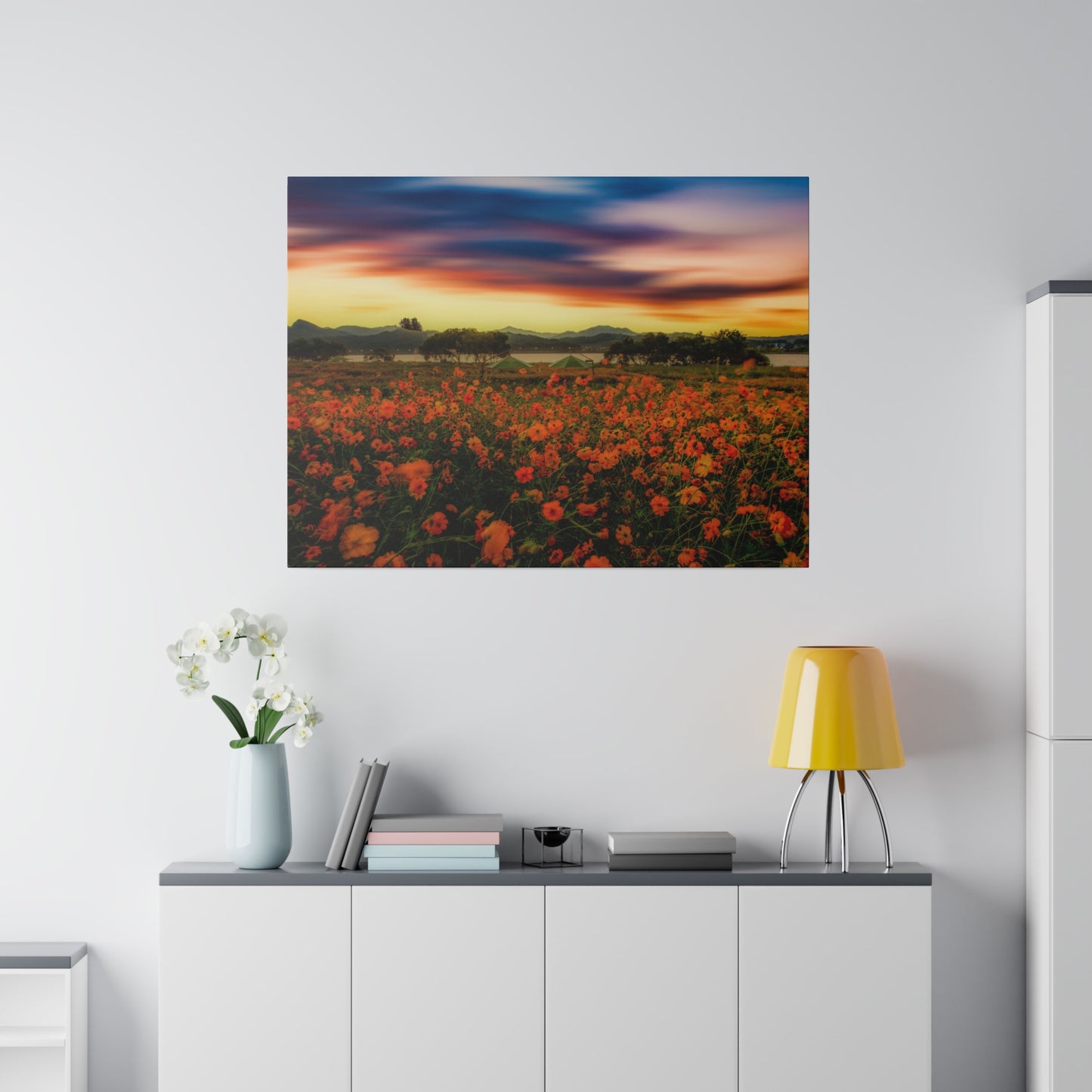 A field of colorful flowers basks in the warm light of the setting sun, with the sky ablaze in shades of orange, pink, and purple.