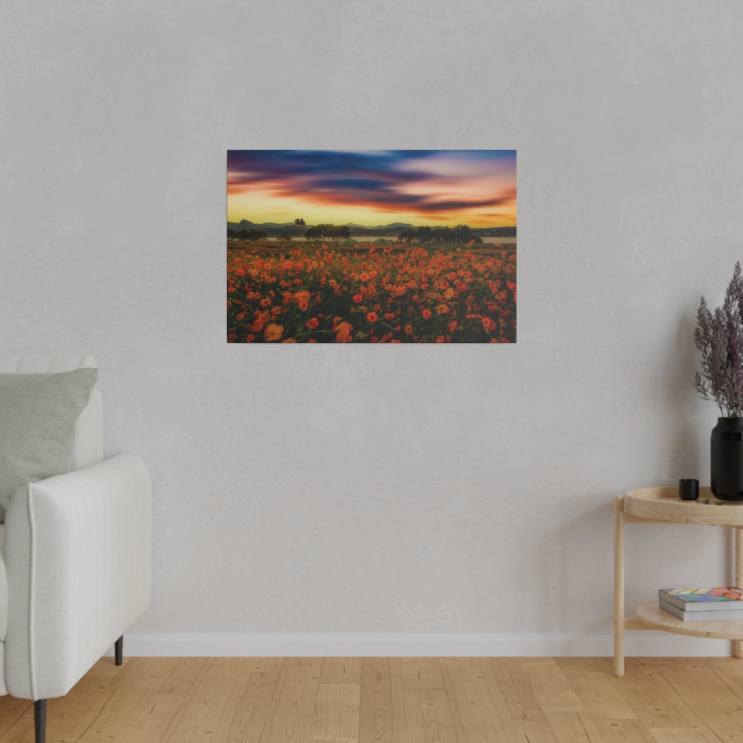 A blooming meadow is bathed in the golden light of sunset, with the sky ablaze in hues of orange, pink, and purple, enhancing the beauty of the flowers.