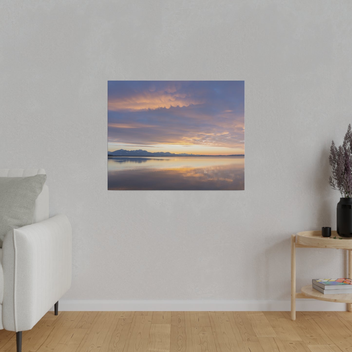 Sunset clouds over a calm lake, with the sky transitioning from orange to purple hues. The still water mirrors the beautiful colors, creating a tranquil atmosphere.
