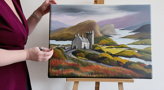 Artist holding a painted canvas featuring a picturesque Scottish landscape with a historic castle, rolling hills, and a serene lake in the background, set on an easel.