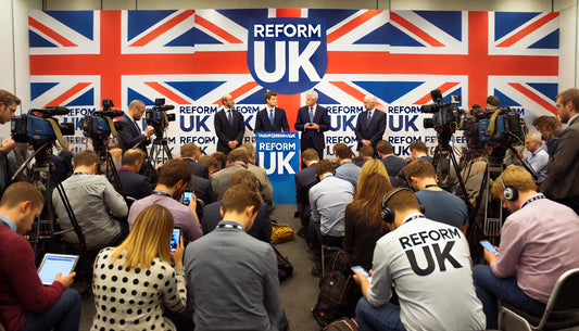 A group of politicians from Reform UK at a press conference. The backdrop features the Reform UK logo and banners with the party's colors. The politicians are engaging with the media, speaking passionately about their policies and future plans.