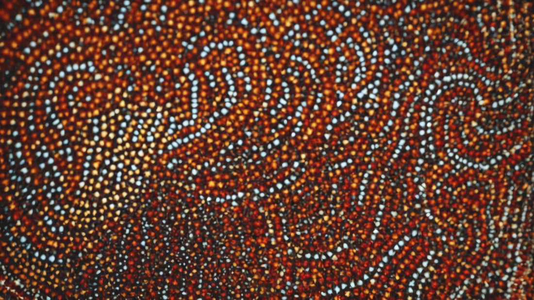 Close-up of Aboriginal dot painting featuring intricate patterns and earthy tones, showcasing the traditional art form's vibrant colors and symbolic designs.