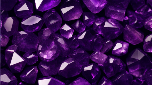 A close-up view of numerous polished amethyst gemstones, displaying their deep, rich purple hues and faceted surfaces that catch the light beautifully.