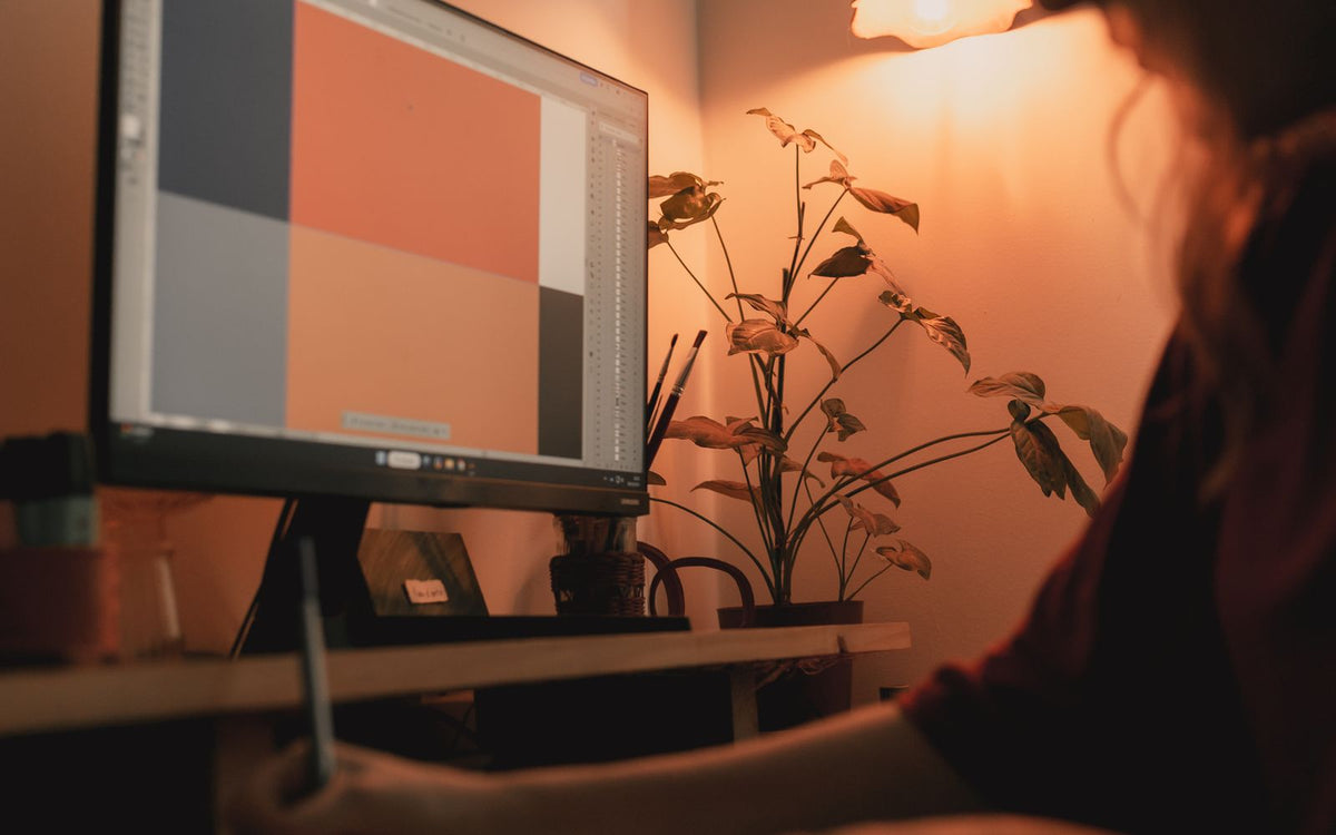 A designer working at a bright, organised creative studio desk