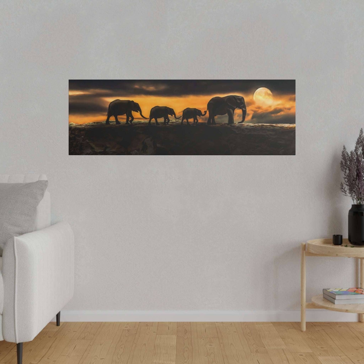 a group of elephants walking across a field at sunset