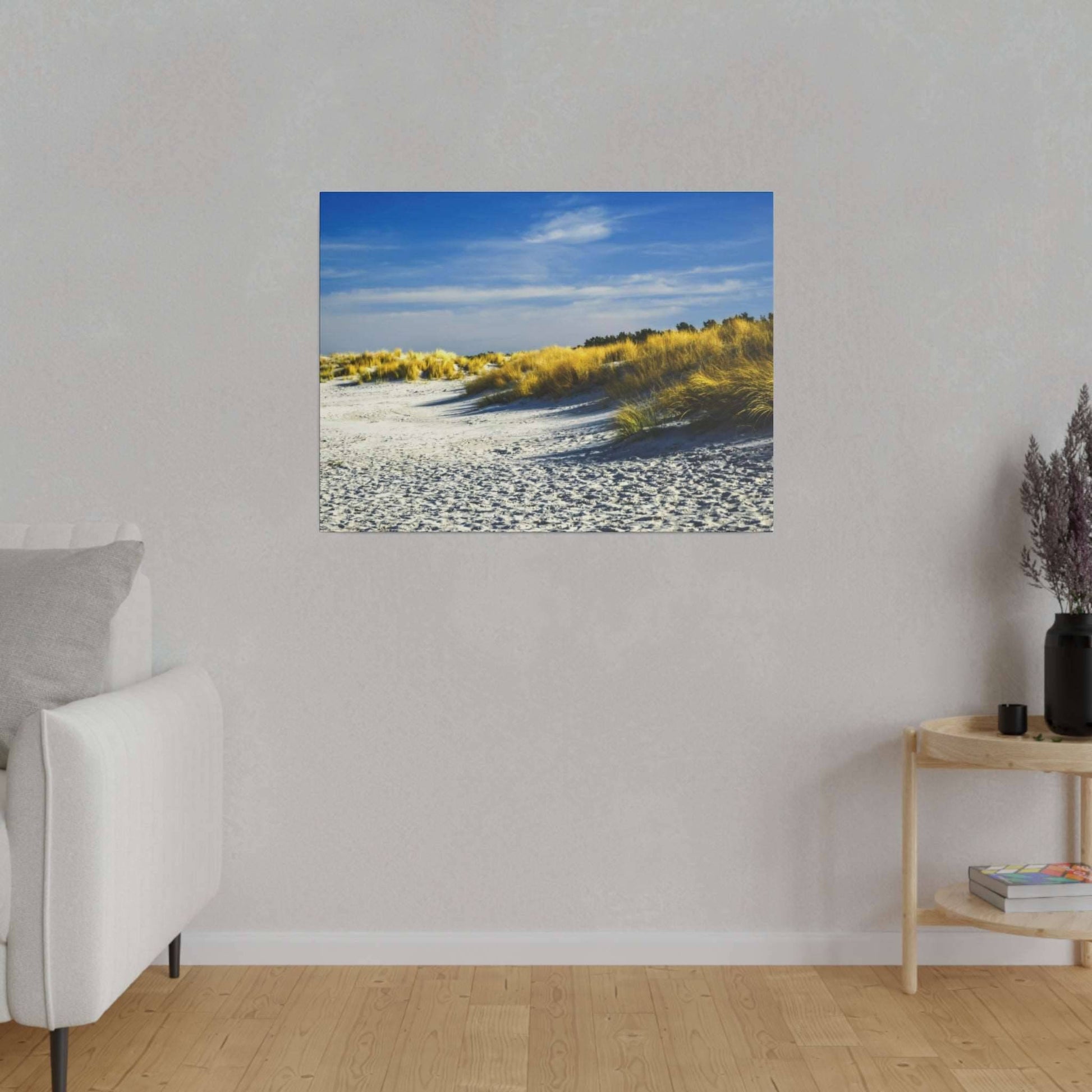 Serene beach with golden grasses and clear blue sky, creating a tranquil and picturesque coastal scene.