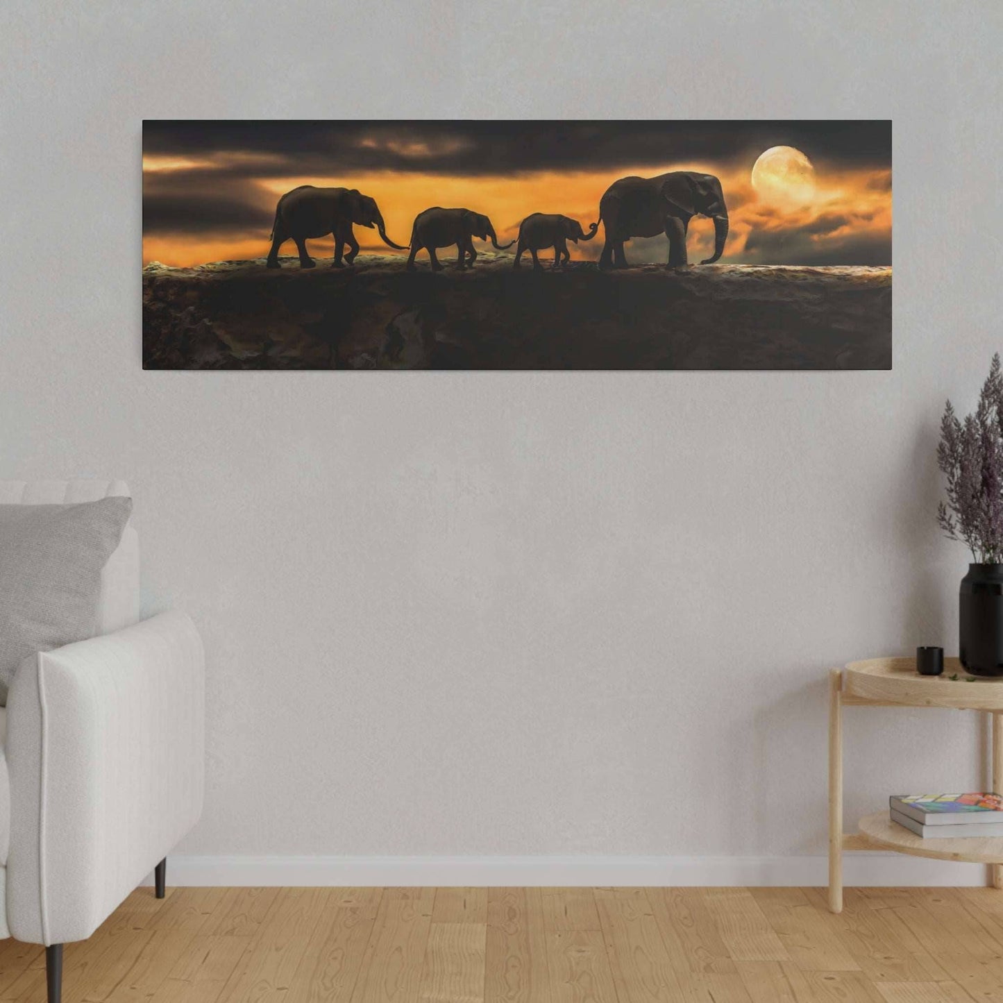 a group of elephants walking across a field at sunset