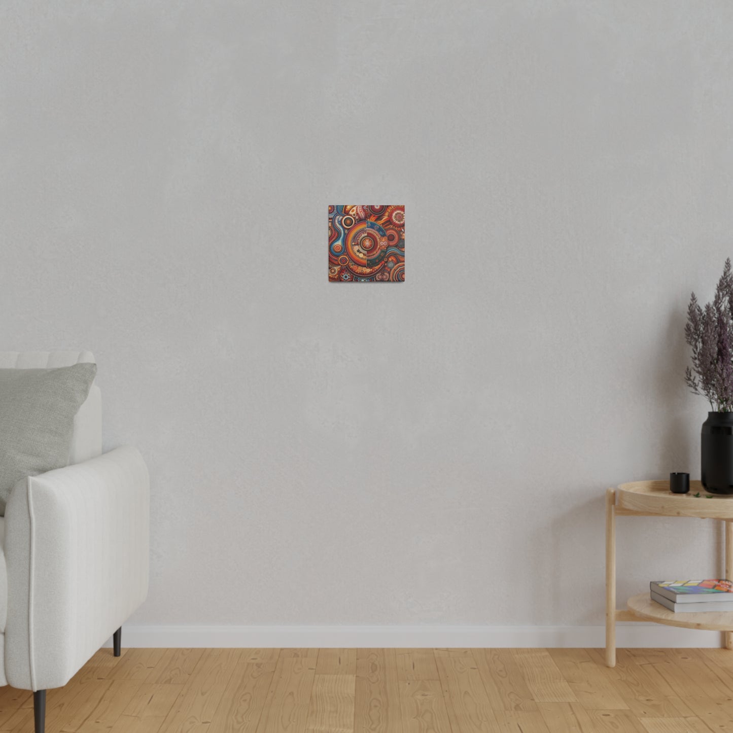 Small square abstract painting with red, orange, and blue swirls hangs on a light gray wall in a minimalist living room.