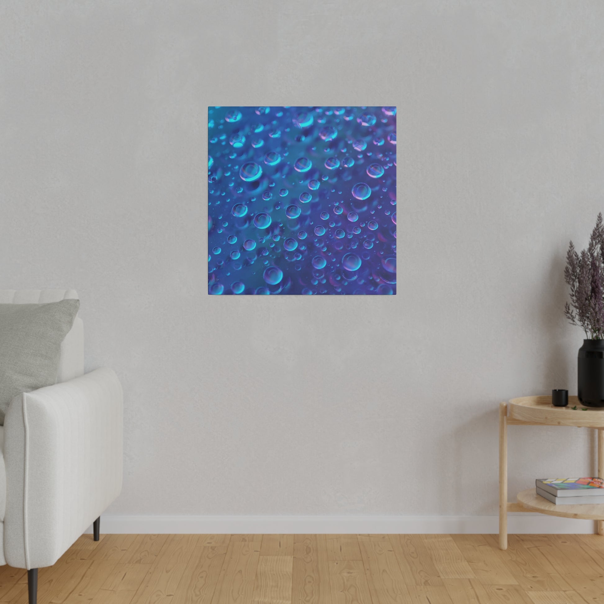 Blue abstract canvas with numerous circular bubbles on a gradient blue background hanging on a light gray wall above a white sofa.