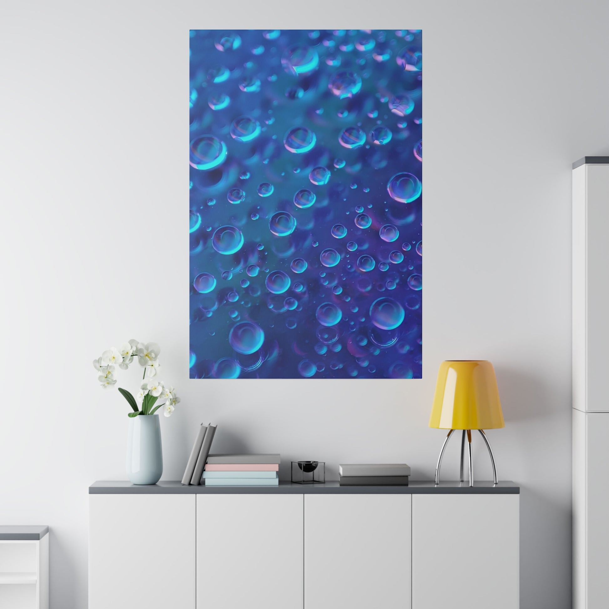 Blue abstract wall art with many bubble-like circles in shades of blue and purple, hung above a white cabinet.