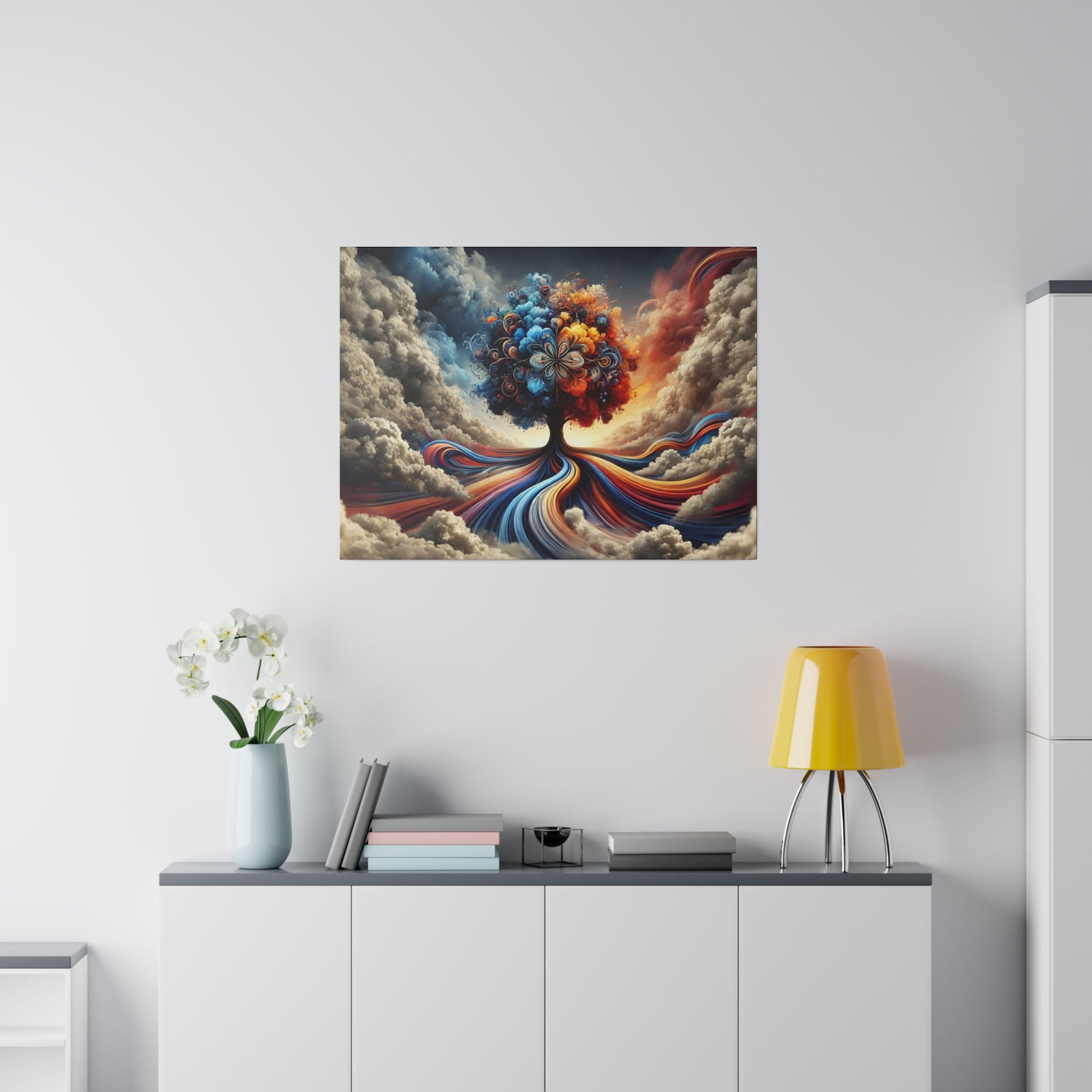 Abstract painting of a colorful tree with swirling roots on a white wall above a gray cabinet with a yellow lamp.