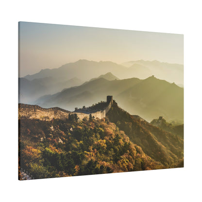 Aerial view of the Great Wall winding over forested mountains in autumn colors at sunrise.