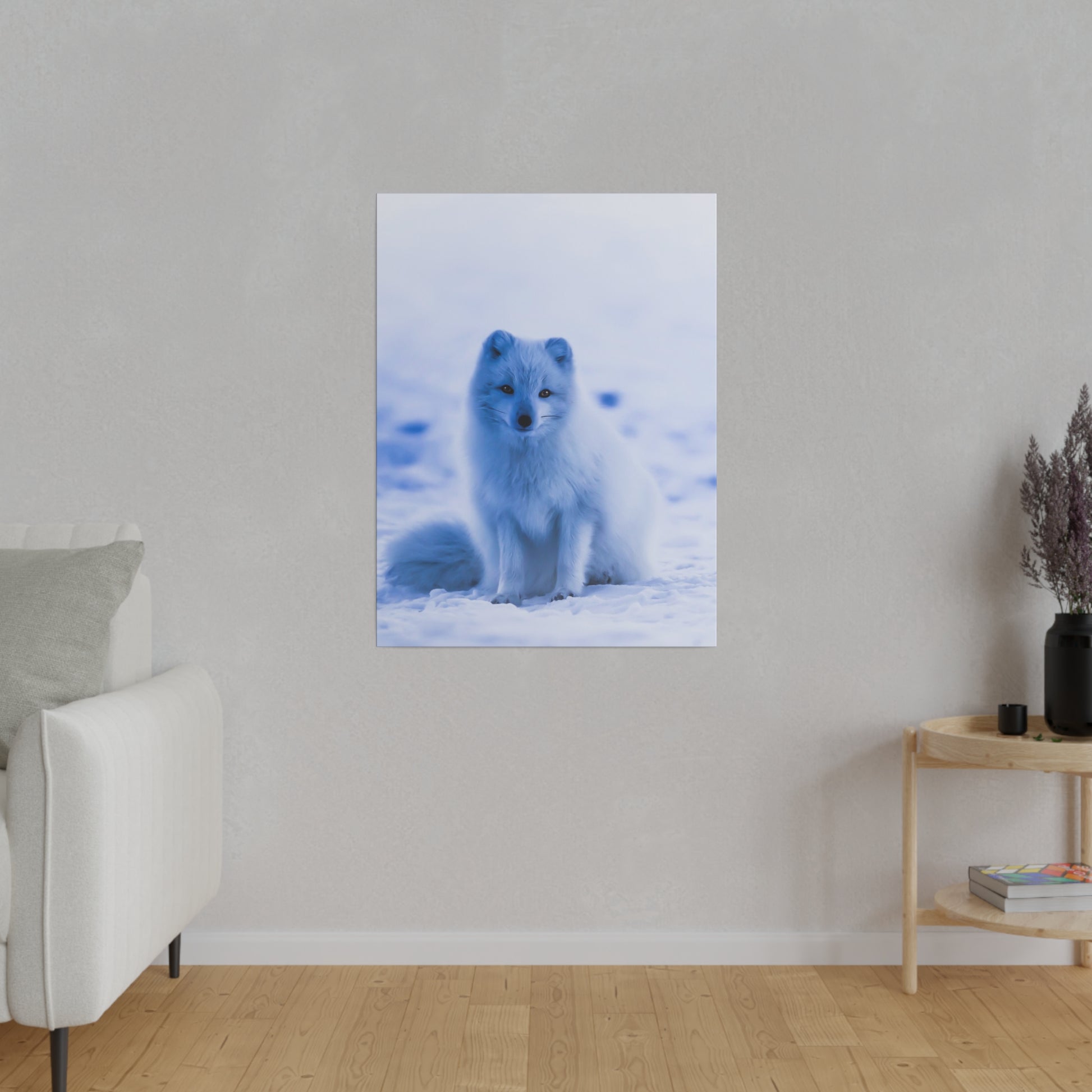 An Arctic fox rests on the snowy ground, its white fur providing excellent camouflage against the winter landscape.