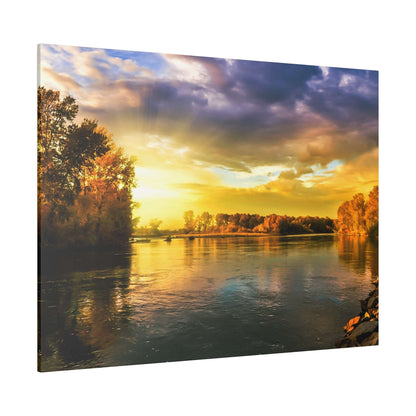 Photograph of a calm river at sunset with orange and yellow sky, reflecting trees along the shore.