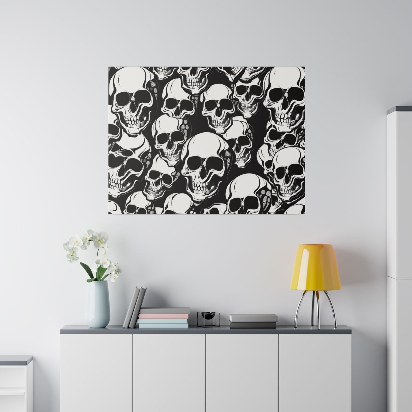Wall art featuring a dense black-and-white skull pattern hanging above a white cabinet.