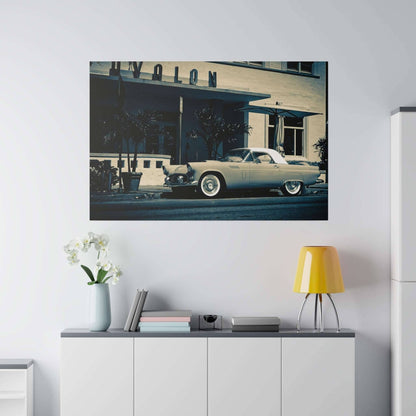 Framed vintage light-blue convertible with a white roof parked on a city street in front of a building.