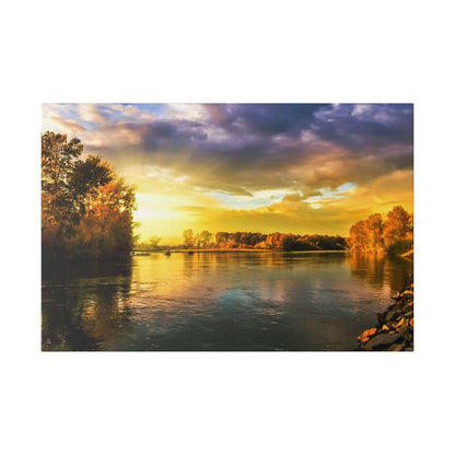 Calm river at sunset with a golden sky and orange reflections on the water, flanked by trees along both banks.