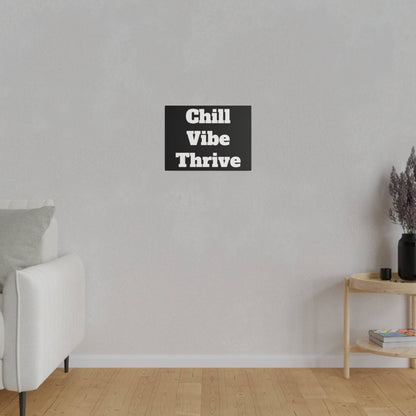Light gray living room with a white sofa on the left, a wooden side table on the right, and a black wall art panel reading “Chill Vibe
