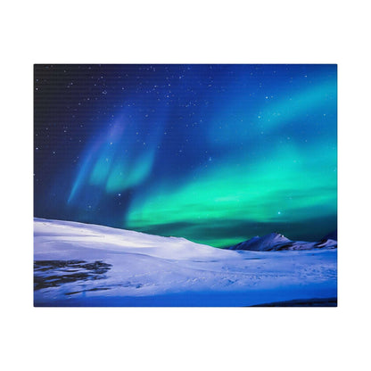 Canvas art on a square canvas showing blue and green Northern Lights over a snow-covered landscape.