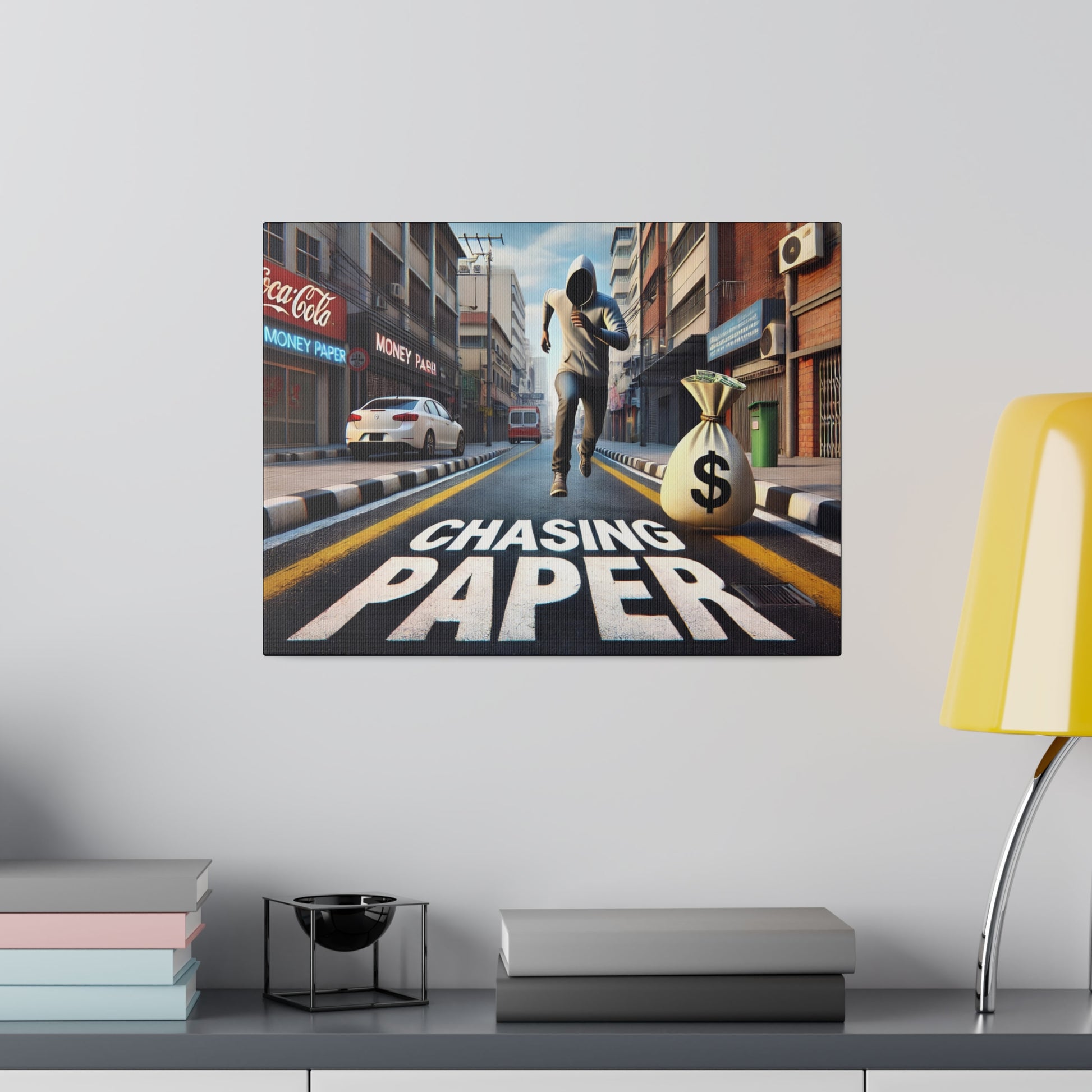 Canvas print of a city street with a masked person jumping beside a large money bag and the text "CHASING PAPER" on the road.