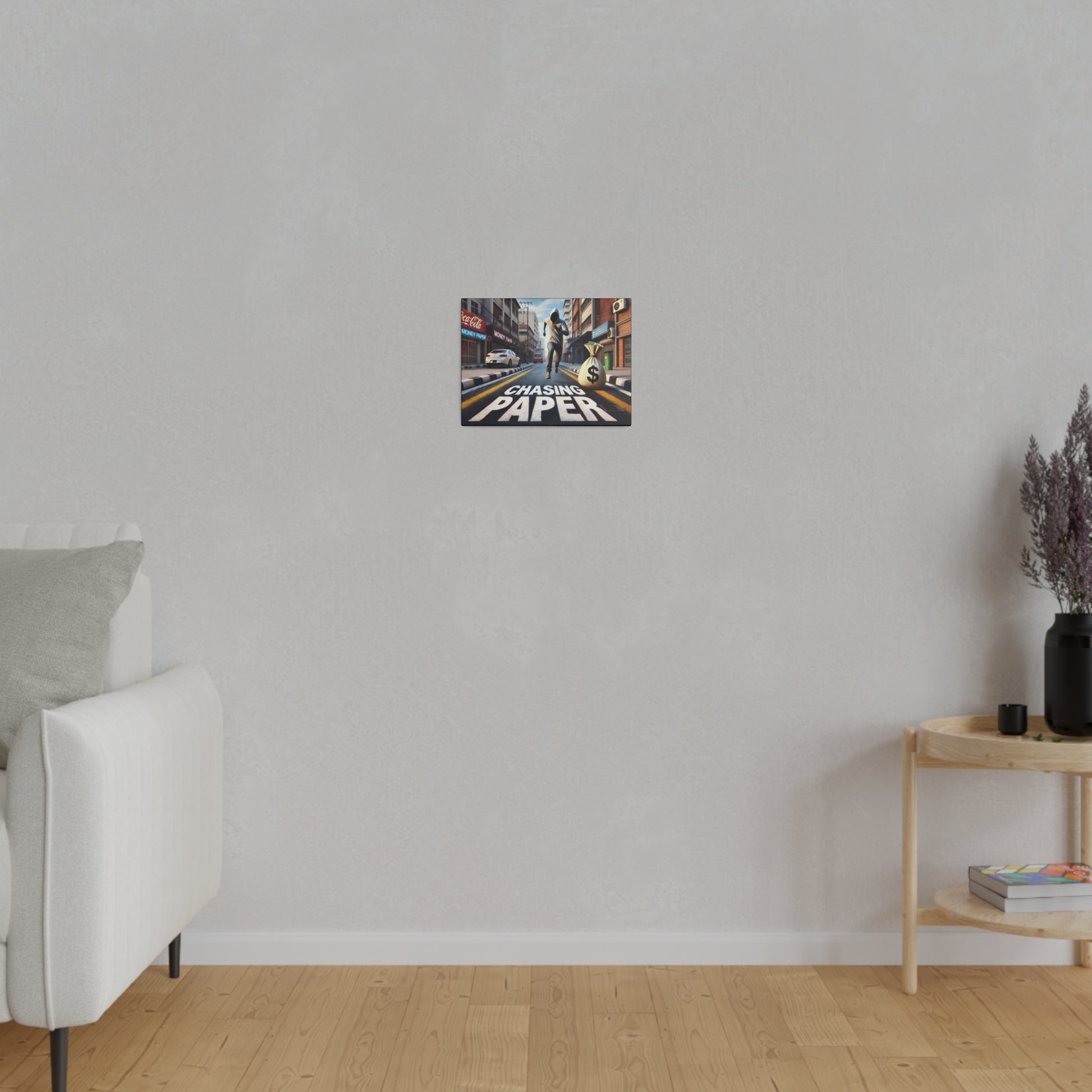 Small, colorful poster mounted on a light gray wall in a living room, showing a city street with the words Chasing Paper.