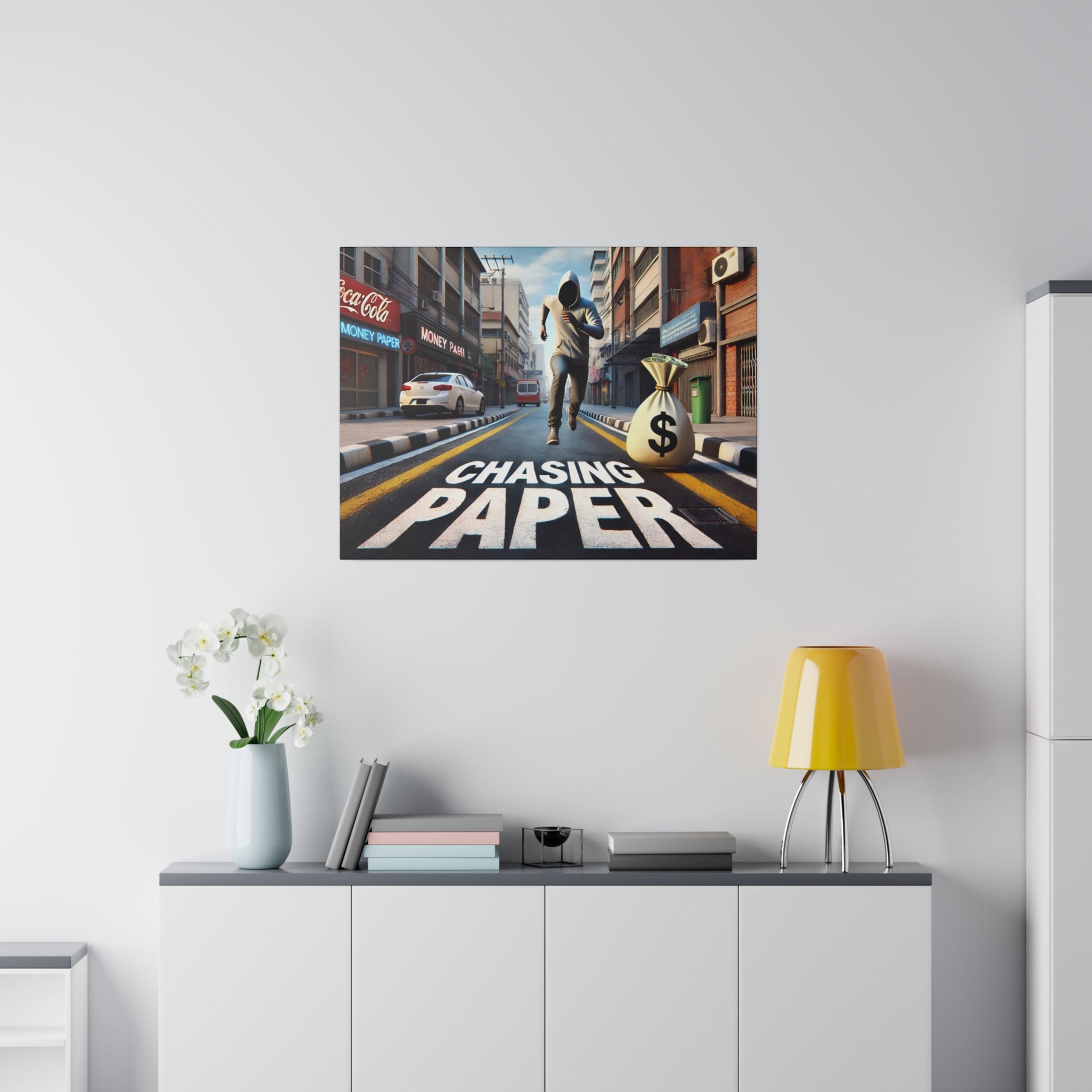 Poster on a white wall showing a street scene with a runner and a money bag, text "Chasing Paper".