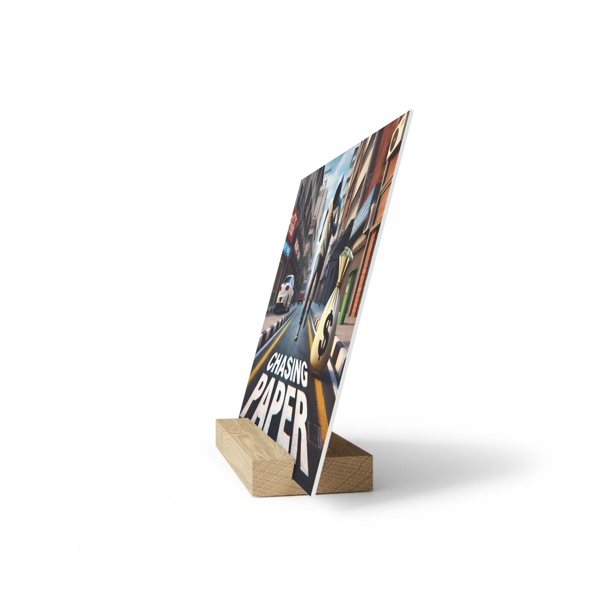 A printed poster showing a city street scene with the text 'Chasing Paper,' angled on a light wooden block stand.