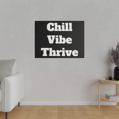 Black rectangular wall art with bold white text reading "Chill Vibe Thrive" hangs on a light gray wall above a white sofa.