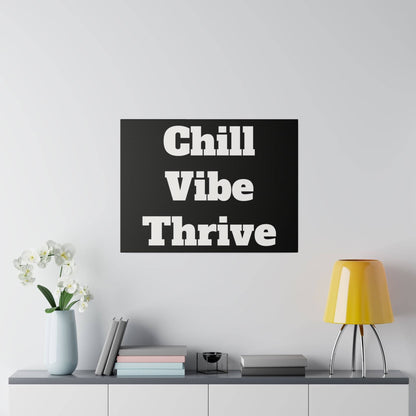 Black square wall art with bold white typography reading "Chill Vibe Thrive" mounted above a gray cabinet.