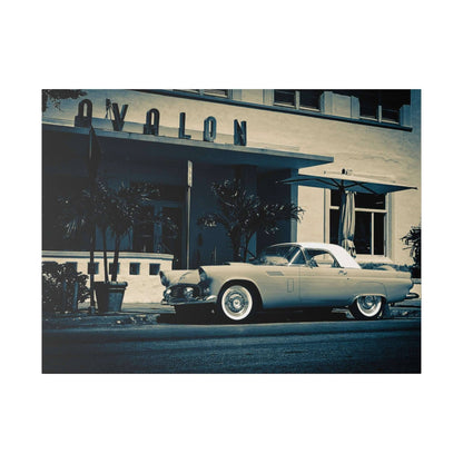 A vintage light-colored convertible with a white roof parked on a street in front of a mid-century storefront.