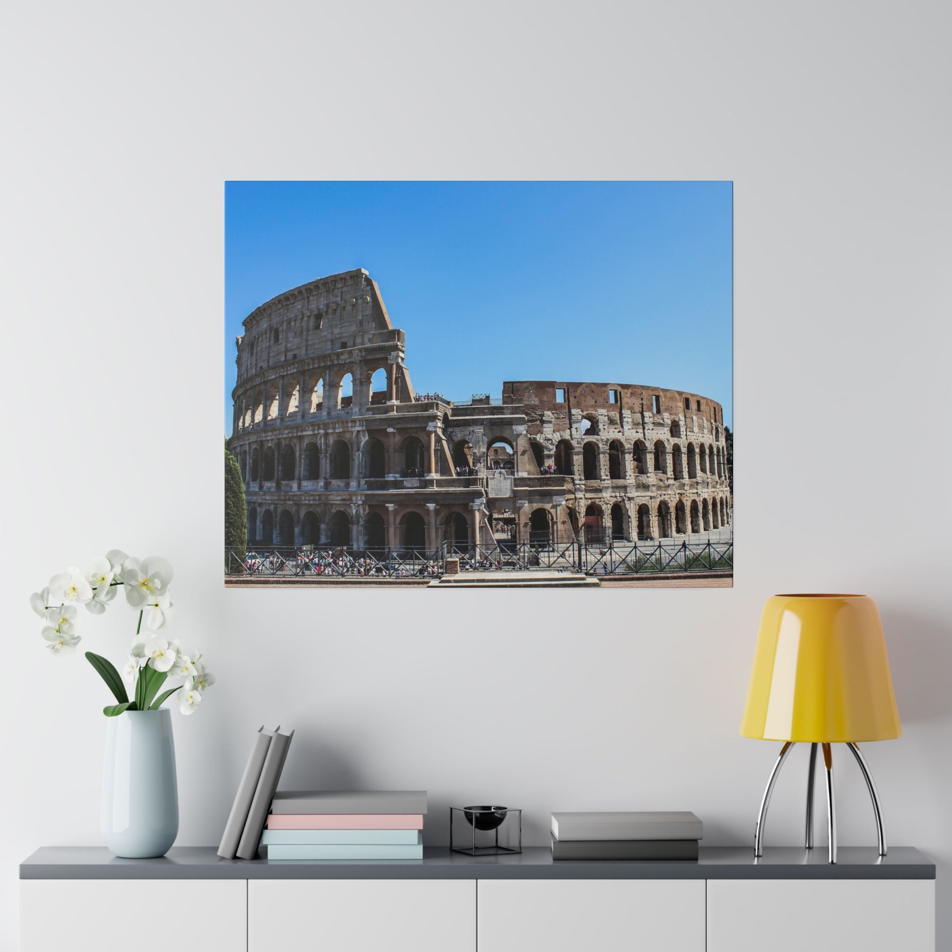 The Colosseum in Rome, an iconic ancient Roman amphitheater, bathed in sunlight under a clear blue sky.