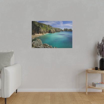 Framed coastal landscape photo depicting turquoise sea, rocky cliffs, and a sandy cove under a blue sky.