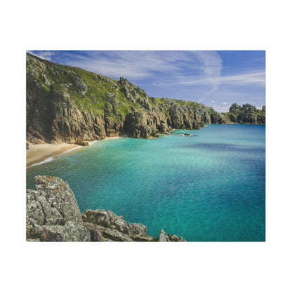 Rocky coastline with steep cliffs, turquoise sea, and a sandy beach cove under a blue sky.