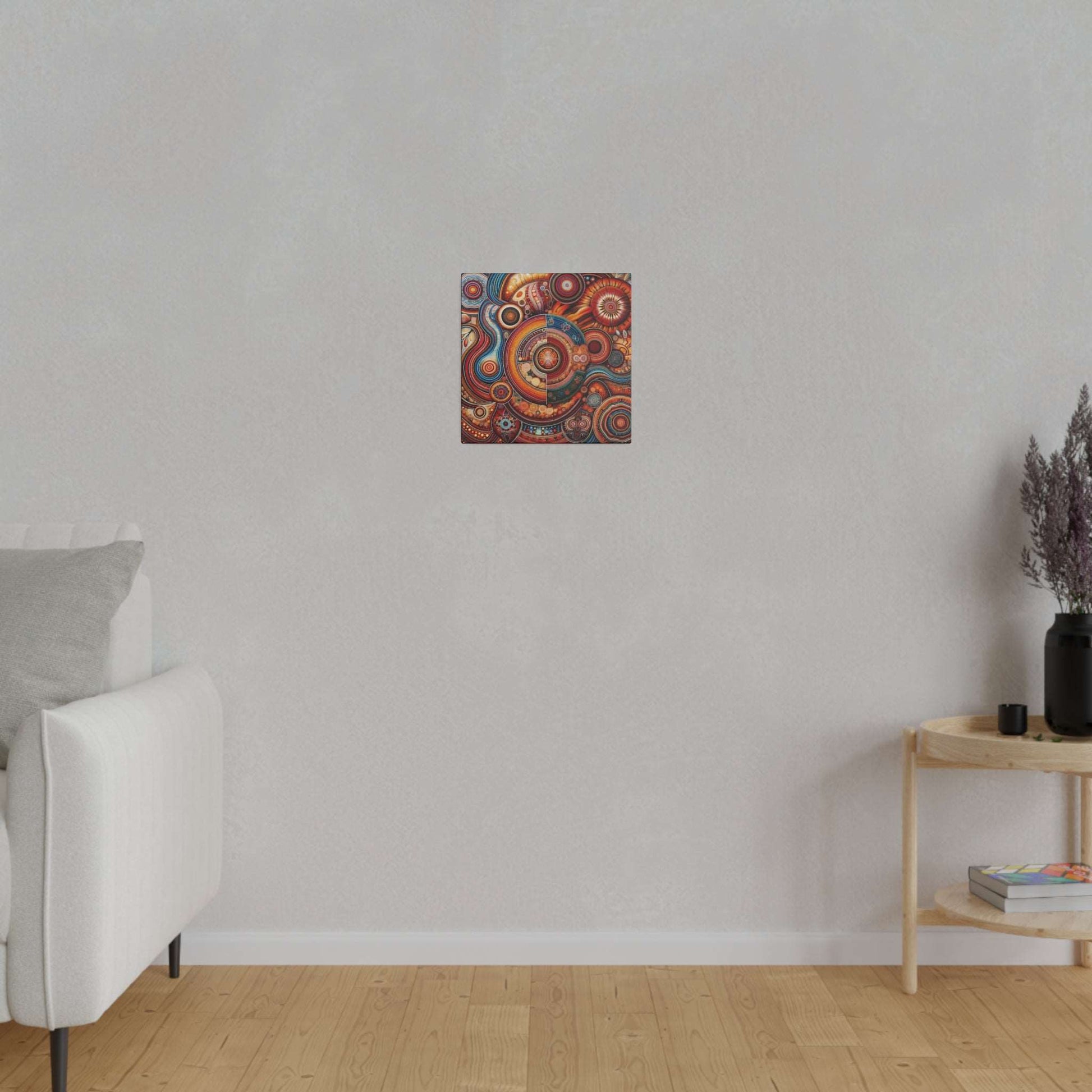 Small square Aboriginal-inspired canvas print with colorful circular patterns hung on a light gray wall above a wooden floor.