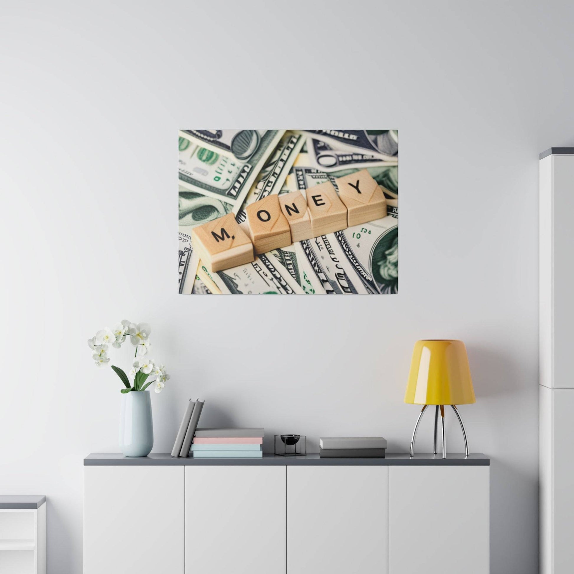 Framed wall art showing wooden letter blocks spelling MONEY atop scattered U.S. dollar bills.