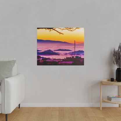 Square wall art print of a sunrise over purple foggy mountains with a yellow-orange sky and silhouetted foreground.