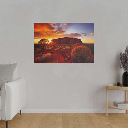 Canvas print of Uluru at sunset, orange sky, red desert and sparse bushes.