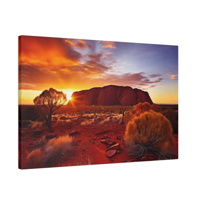 An Uluru sunset canvas print showing a red rock formation, desert scrub, and a vibrant orange sky.