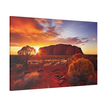 Canvas print of Uluru at sunset: red desert, orange sky, and sparse desert shrubs in the foreground.
