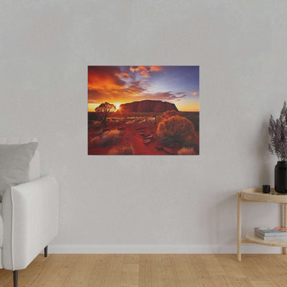 Canvas print showing Uluru at sunset with red desert terrain, orange sky, and sparse bushes.