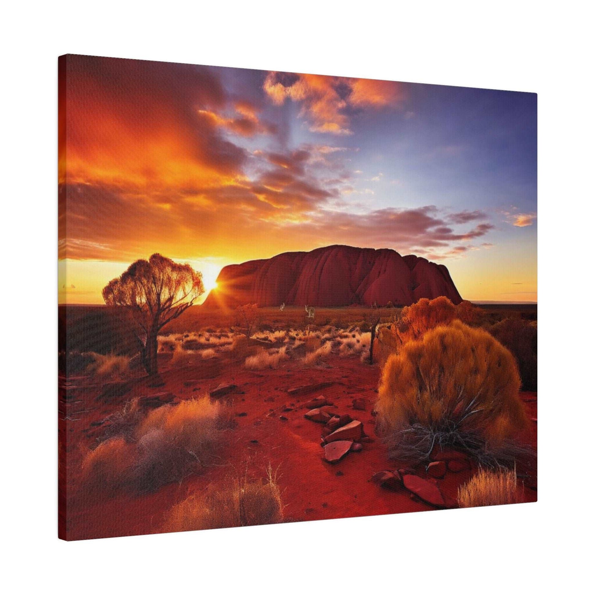 Desert landscape at sunset featuring Uluru rock formation, orange-red soil, and sparse shrubs.