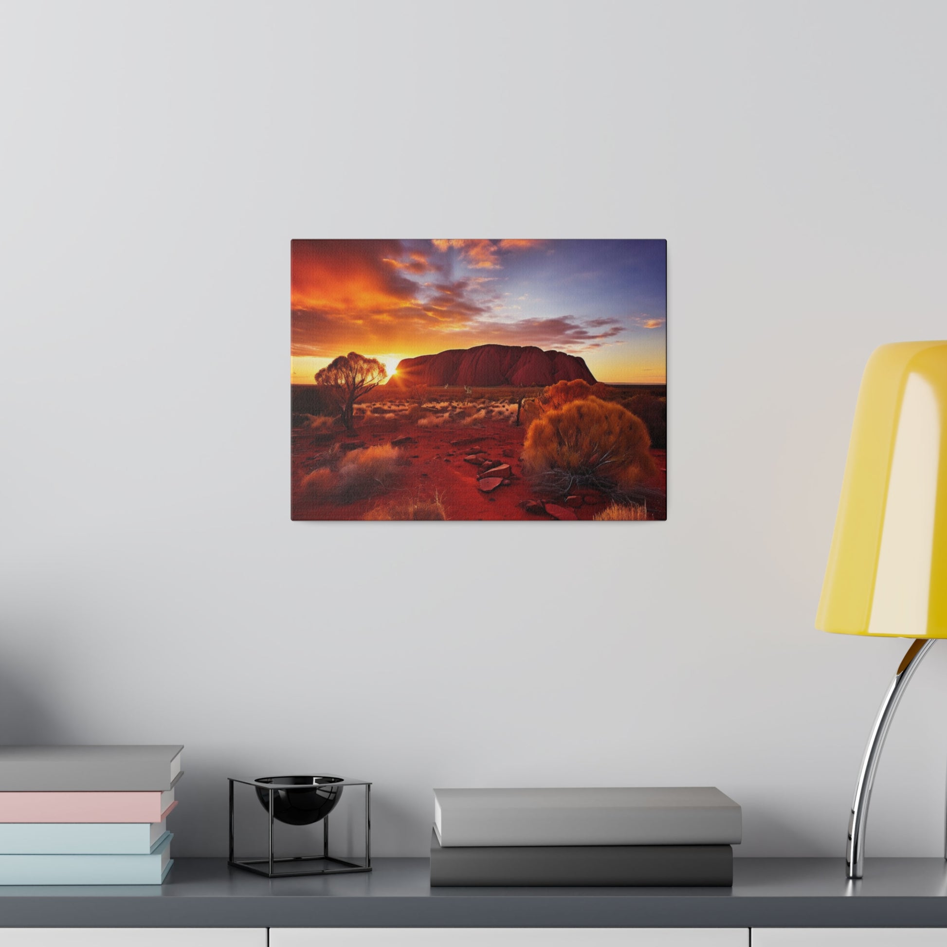 Square wall art showing a desert landscape at sunset with red rocks, trees, and scrubby bushes.