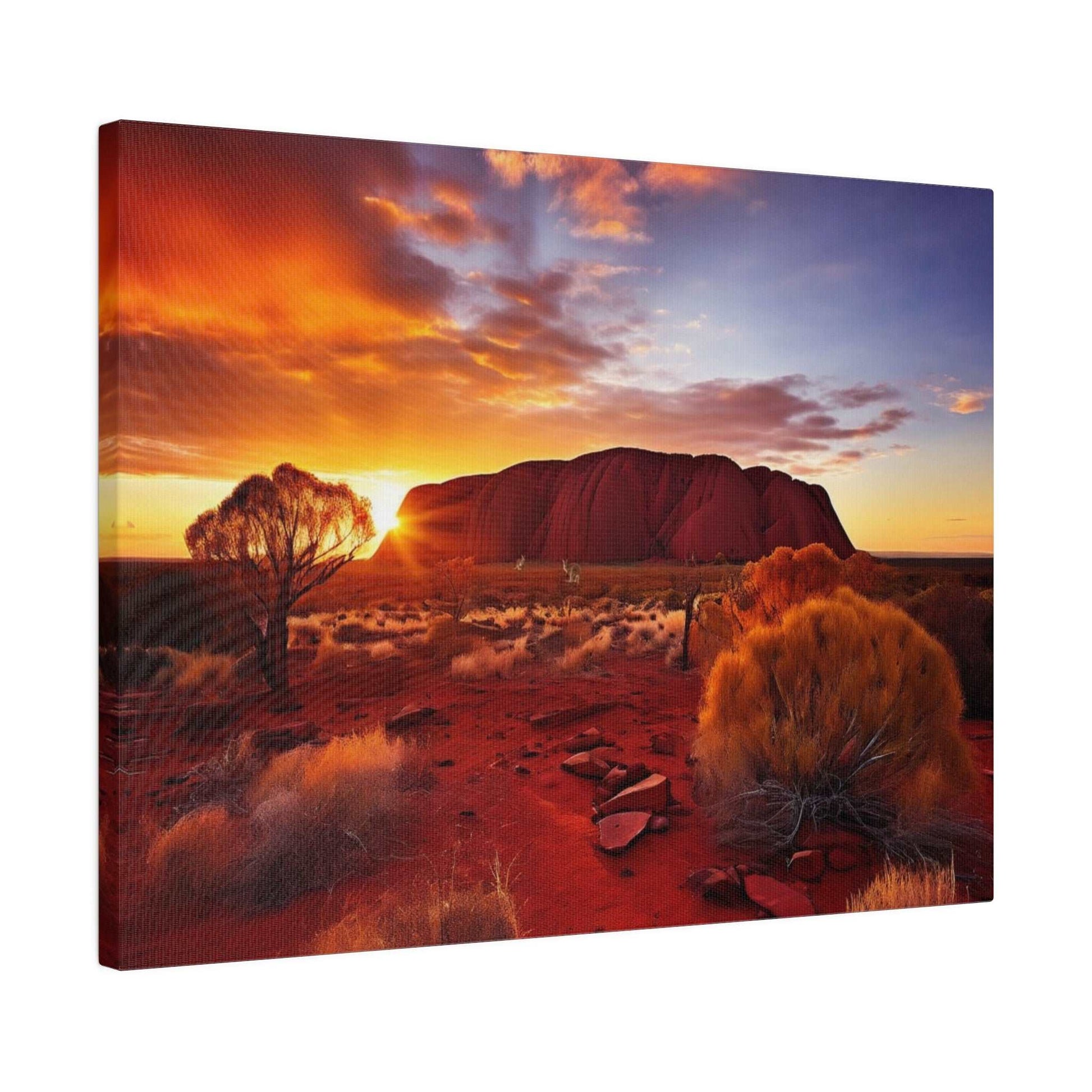 Canvas print of a desert landscape with Uluru at sunset, orange sky, red soil, and sparse shrubs.