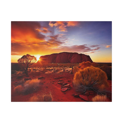 Australia desert landscape at sunset with Uluru rock in background, orange-red sands and scrubby bushes.