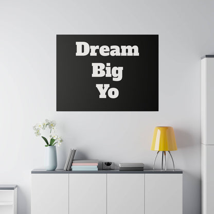 Black square wall art with large white bold text reading 'Dream Big Yo' mounted above a white cabinet.