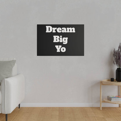 Black rectangular canvas on a light gray wall reads 'Dream Big Yo' in bold white letters.
