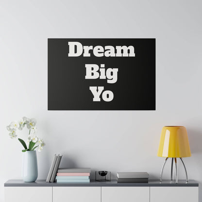 Black rectangular wall art with large white letters reading "Dream Big Yo" stacked in three lines.