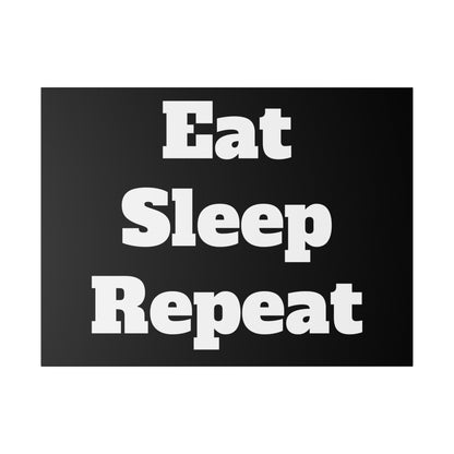 Black rectangular sign with bold white text saying “Eat Sleep Repeat” across three lines.